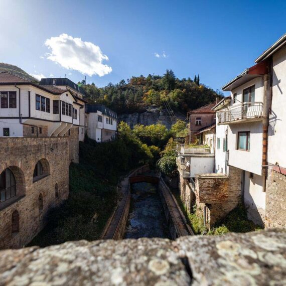 Stone bridge across a canal between traditional buildings in Kratovo
